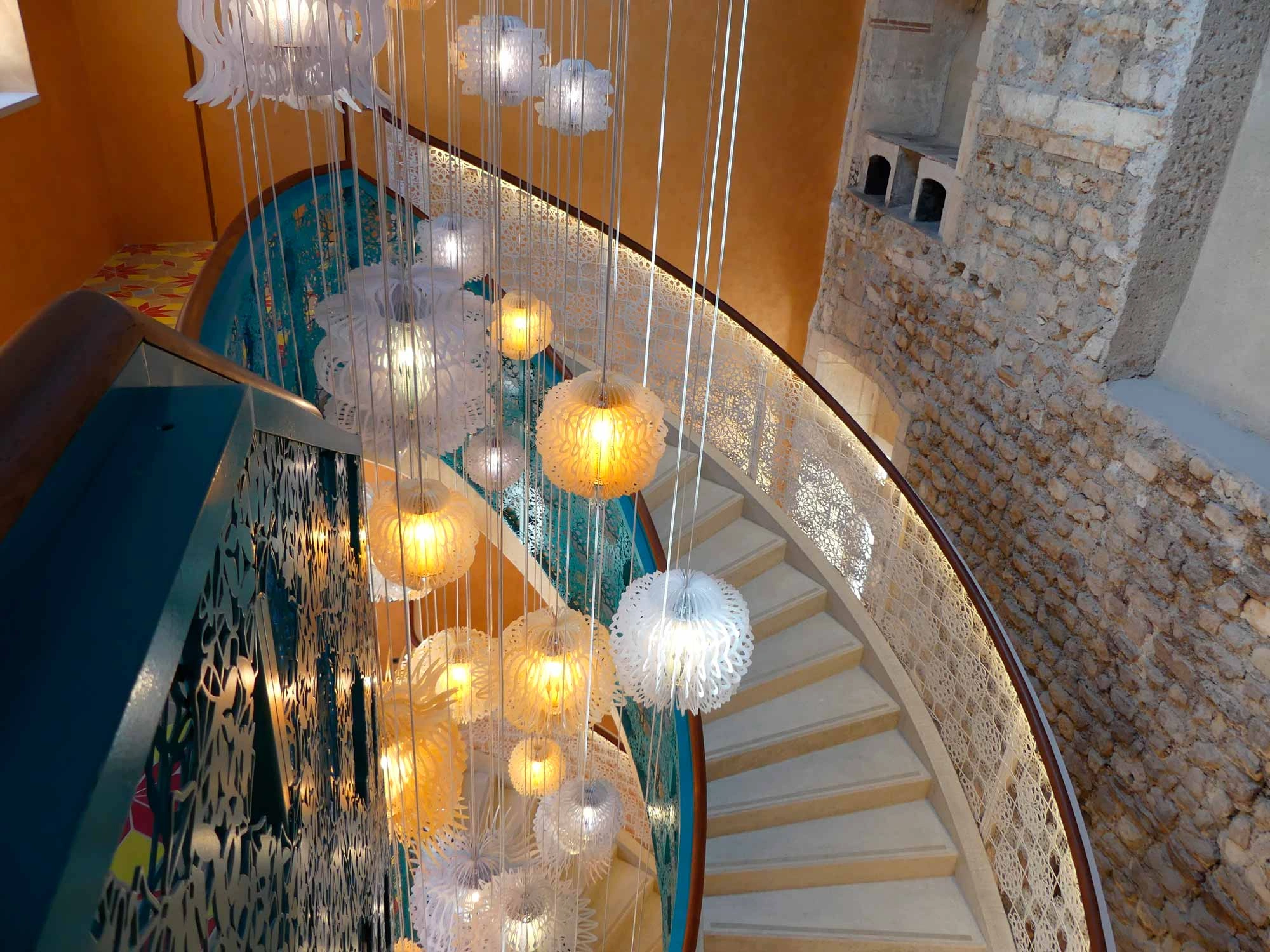 L'escalier principal achevé de l'Hôtel Arlatan, entre garde-corps ajouré et maçonnerie antique